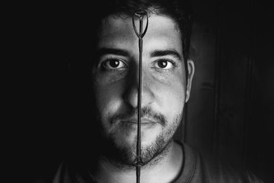 Portrait of young man against black background