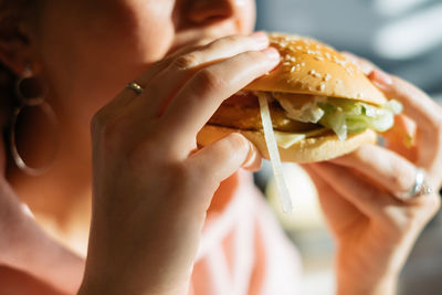 Midsection of woman eating burger