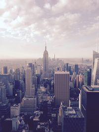 Empire state building amidst cityscape against sky