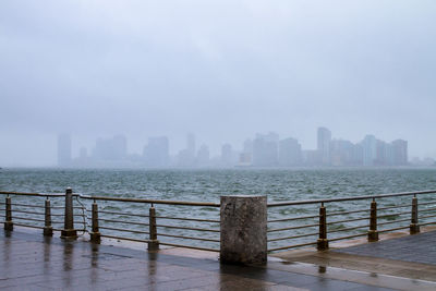 Skyline seen from promenade by sea in foggy weather