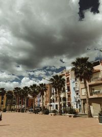 Buildings in city against cloudy sky