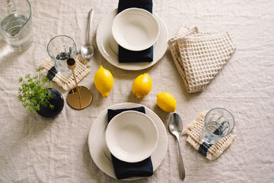 Vintage table setting with linen napkins and yellow lemons.