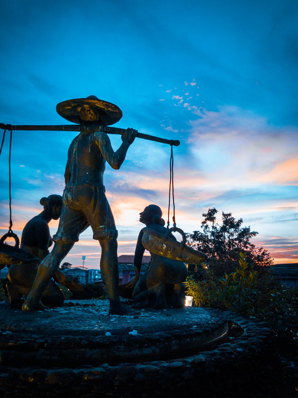 STATUE OF MAN STANDING BY FOUNTAIN AGAINST SKY