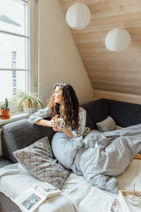 Woman sitting on sofa at home
