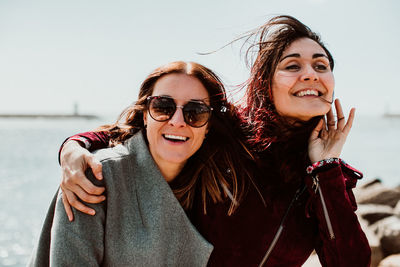 Smiling women looking away against sky