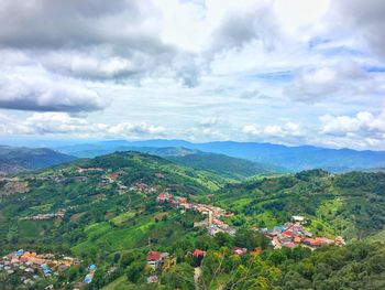 Scenic view of townscape and mountains against sky