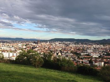 View of cityscape against cloudy sky