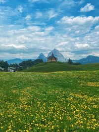 Scenic view of field against cloudy sky