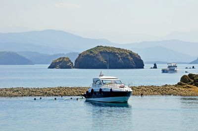 Boat in sea against mountains