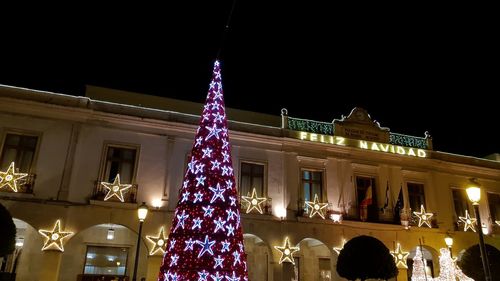 Low angle view of illuminated christmas tree at night