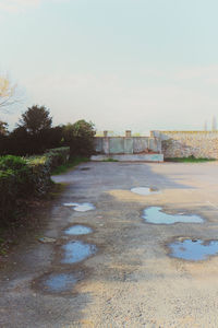 Puddle on landscape against sky