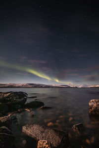 Borealis aurora sweeps over a large lake on a cloudless night in kilpisjarvi, lapland, finland. 