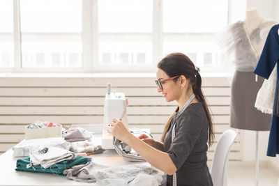 Side view of a woman working on table