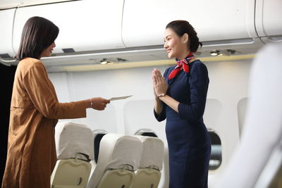 Woman standing by airplane at airport