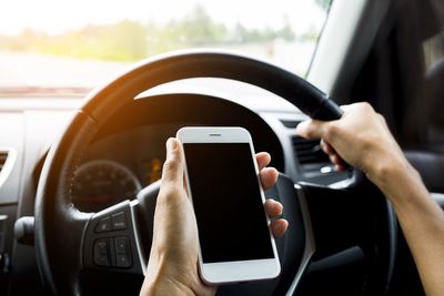 Midsection of man using mobile phone in bus