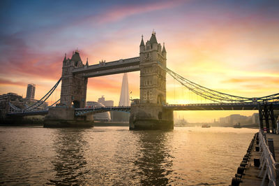 View of bridge over river at sunset