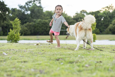 Side view of woman with dog on field