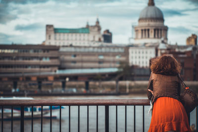 Rear view of woman standing against river