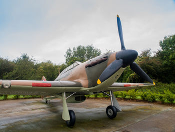 Side view of airplane on airport runway against sky