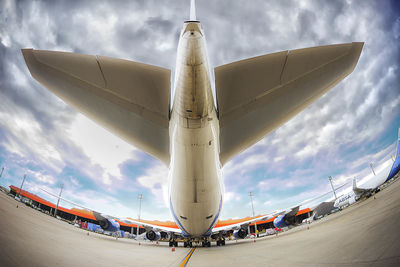 Airplane on runway against sky