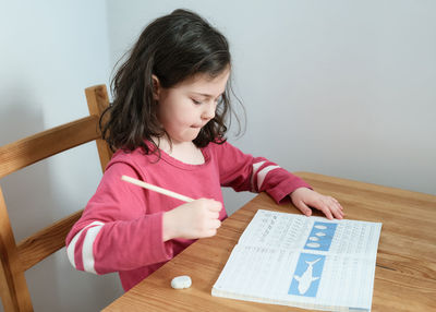 Young girl practicing her writing at the table