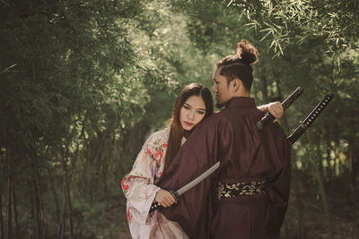 Rear view of couple standing in forest
