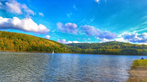 Scenic view of lake by mountains against sky