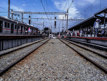 Railroad tracks in city against sky