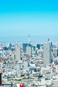 Aerial view of buildings in city against clear blue sky