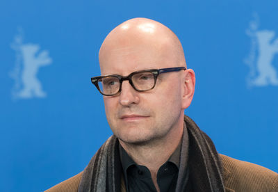 Portrait of man wearing eyeglasses against blue sky