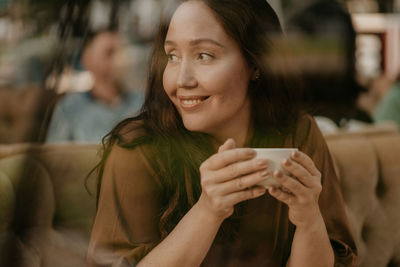 Portrait of young woman drinking coffee