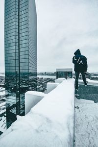 Man standing on snow covered city in winter