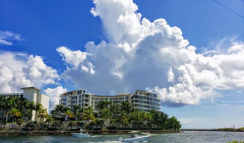 Buildings by sea against sky