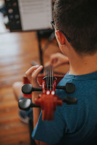 High angle view of teenage boy playing guitar at home