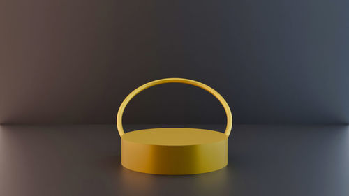 Close-up of yellow lamp on table against wall