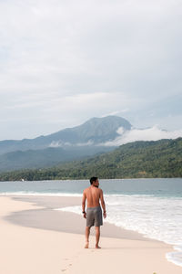 Rear view of shirtless man standing on banana island
