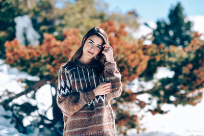 Portrait of woman against trees during winter