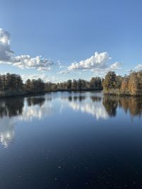 Scenic view of lake by trees against sky