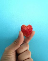 Close-up of hand holding strawberry heart shape