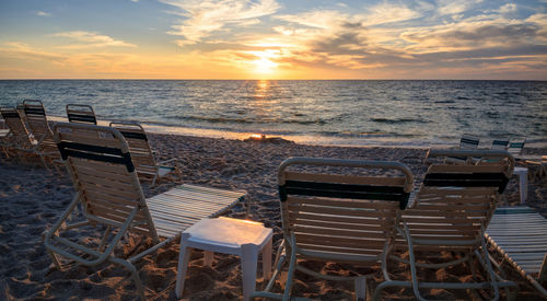Chairs along vanderbilt beach in naples, florida, usa at sunset