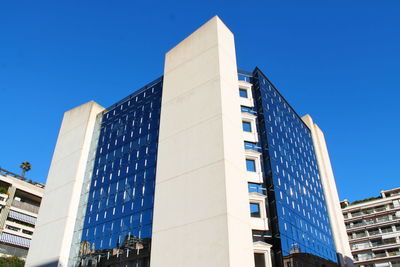 Low angle view of modern buildings against clear blue sky