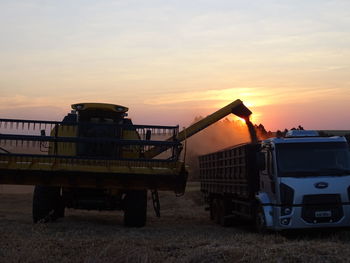 Built structure on agricultural field against sky during sunset