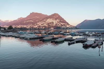 Boats moored in lake against clear sky