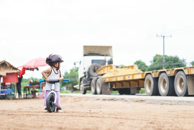 Full length of boy with bicycle at roadside