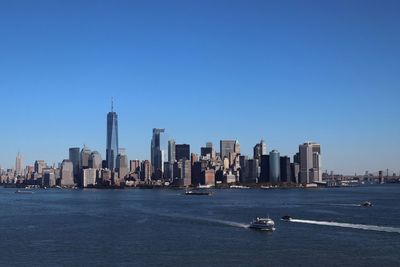 City at waterfront against blue sky