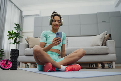 Portrait of young woman sitting on sofa at home