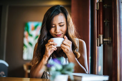 Portrait of woman drinking coffee in cafe