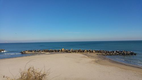 Scenic view of sea against clear blue sky