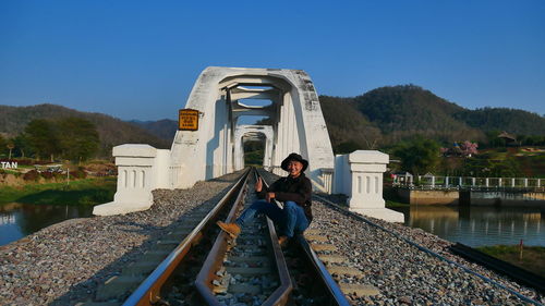 Rear view of man walking on railroad track