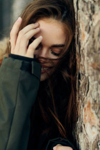 Portrait of beautiful young woman with tree trunk